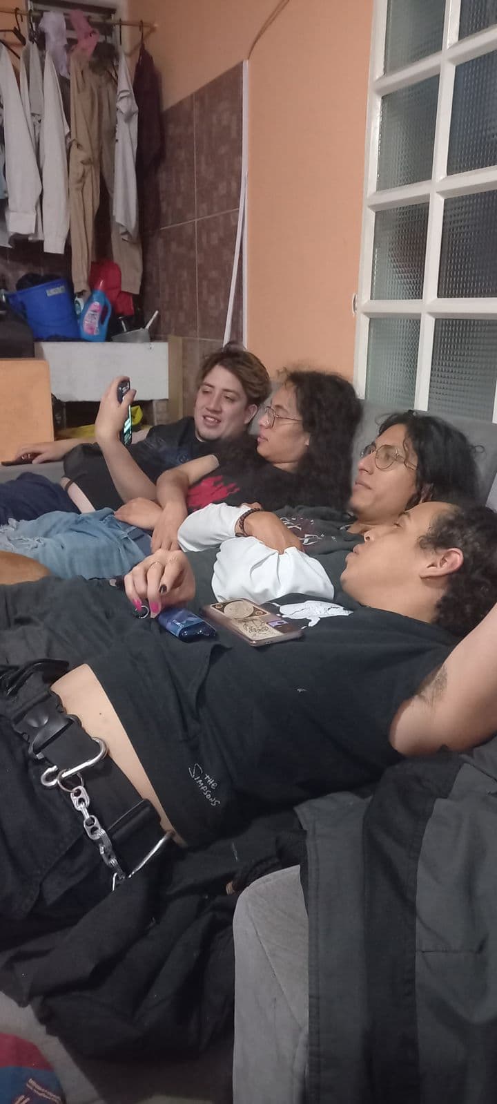Hombres de la banda conviviendo en un sofá
